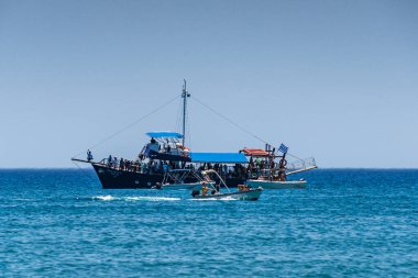 Yunanistan 'ın Lagana kenti - 8 Haziran 2024: Turistler yaz etkinliklerinin ve Laganas sahilindeki bir yolcu teknesiyle Zakynthos adasını gezmenin keyfini çıkarıyorlar. Zakynthos, Batı Yunanistan 'da İyon Denizi.