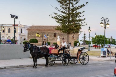 Zakynthos, Yunanistan - 6 Haziran 2024: Yaz döneminde Zakynthos adasında turistleri bekleyen geleneksel at arabası. Batı Yunanistan 'daki Zakynthos adasının kentsel manzarası.