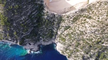 Yunanistan 'ın Zakynthos adasındaki ünlü Navagio plajı (Batık Kumsalı) üzerinde hava manzarası. İyon Denizi 'nin, Navagio' nun ya da Batık Sahili 'nin en güzel mücevherlerinden biri Zakynthos' un dünyaca ünlü doğal görüntüsünden sonra açık ara en popüler mekanıdır.