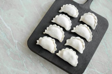 Tahta kesme tahtasının üzerinde içi doldurulmuş güzel hamur köfteleri. Lezzetli fast food