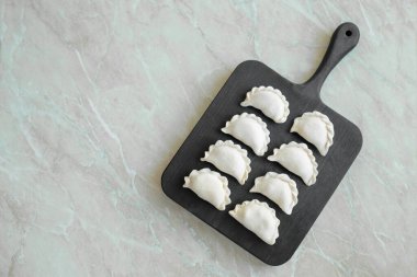 Tahta kesme tahtasının üzerinde içi doldurulmuş güzel hamur köfteleri. Lezzetli fast food