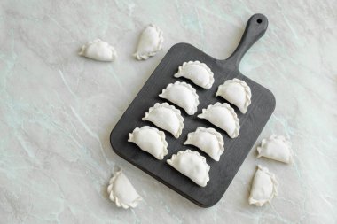 Tahta kesme tahtasının üzerinde içi doldurulmuş güzel hamur köfteleri. Lezzetli fast food