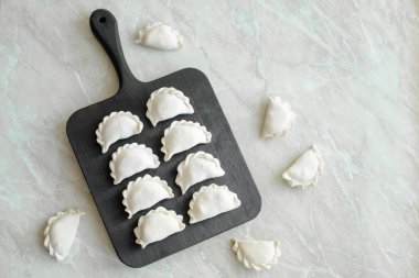 Tahta kesme tahtasının üzerinde içi doldurulmuş güzel hamur köfteleri. Lezzetli fast food