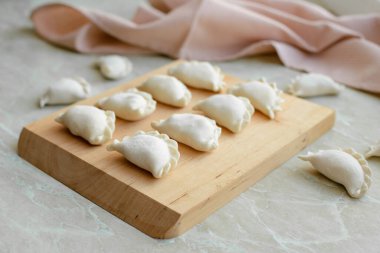 Tahta kesme tahtasının üzerinde içi doldurulmuş güzel hamur köfteleri. Lezzetli fast food