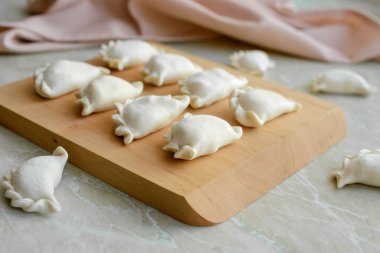 Tahta kesme tahtasının üzerinde içi doldurulmuş güzel hamur köfteleri. Lezzetli fast food