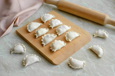 Tahta kesme tahtasının üzerinde içi doldurulmuş güzel hamur köfteleri. Lezzetli fast food