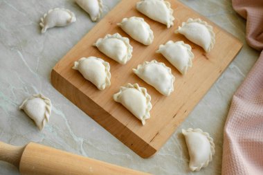 Tahta kesme tahtasının üzerinde içi doldurulmuş güzel hamur köfteleri. Lezzetli fast food