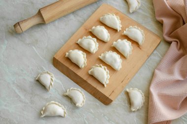 Tahta kesme tahtasının üzerinde içi doldurulmuş güzel hamur köfteleri. Lezzetli fast food