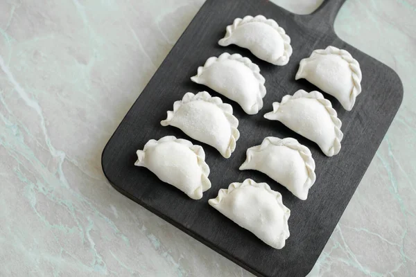 Tahta kesme tahtasının üzerinde içi doldurulmuş güzel hamur köfteleri. Lezzetli fast food