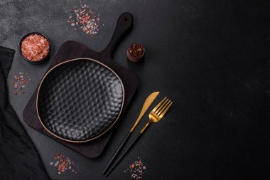 Siyah boş tabak, çatal bıçak takımı ve peçete. Tablo ayarı