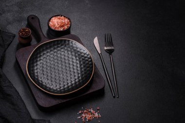 Siyah boş tabak, çatal bıçak takımı ve peçete. Tablo ayarı