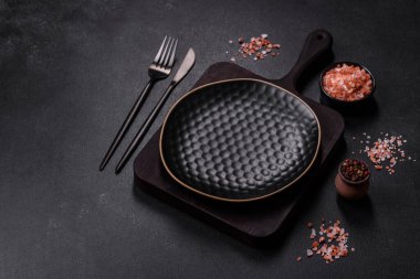 Siyah boş tabak, çatal bıçak takımı ve peçete. Tablo ayarı