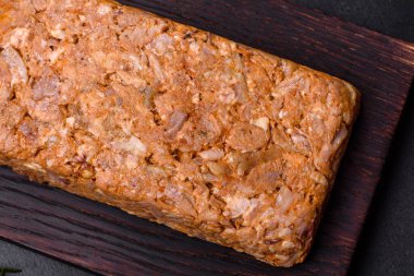 Lezzetli et, ahşap bir kesme tahtasının üzerinde koyu beton bir arka planda baharat ve bitkilerle kas gücü ya da yuvarlanıyor.