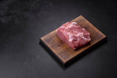 Taze çiğ domuz eti, baharatlar, tuz ve otlar ahşap bir kesme tahtasının üzerinde. Evde ızgara yemek pişirmek.