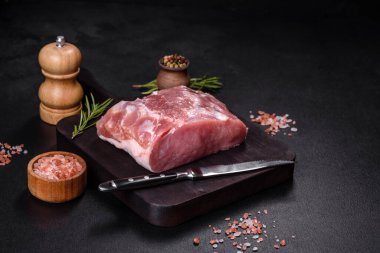 Taze çiğ domuz eti, baharatlar, tuz ve otlar ahşap bir kesme tahtasının üzerinde. Evde ızgara yemek pişirmek.