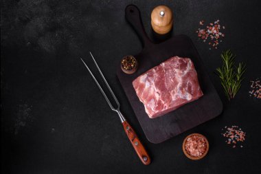 Taze çiğ domuz eti, baharatlar, tuz ve otlar ahşap bir kesme tahtasının üzerinde. Evde ızgara yemek pişirmek.