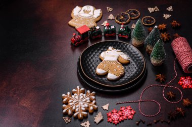Kahverengi beton bir masada farklı Noel süslemeleri ve zencefilli çörekler. Yeni yıl kutlamaları için hazırlık
