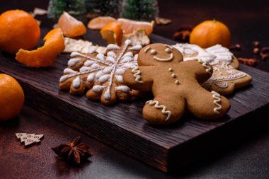 Bayram oyuncakları, mandalinalar ve koyu beton arka planda zencefilli çöreklerle güzel Noel süslemeleri. Noel masasını hazırlıyorum.