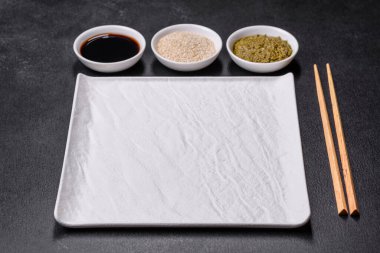 Koyu beton arka planda Asya yemekleri için tahta çubuklu boş tabak. Asya mutfağının hazırlanması