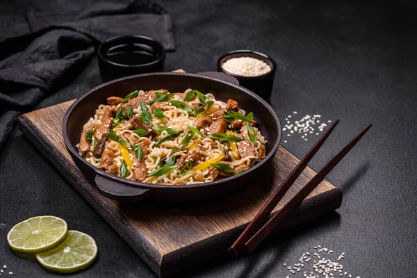 暗いコンクリートの背景に米麺 アスパラガス コショウ ゴマや醤油とアジア料理のおいしい料理 — ストック写真