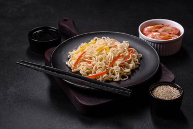 Lezzetli taze pirinç eriştesi, karides, baharat ve çimento arka planda bitkiler.