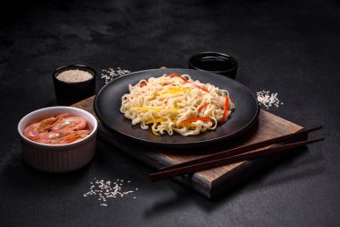 Lezzetli taze pirinç eriştesi, karides, baharat ve çimento arka planda bitkiler.