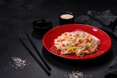 Lezzetli taze pirinç eriştesi, karides, baharat ve çimento arka planda bitkiler.