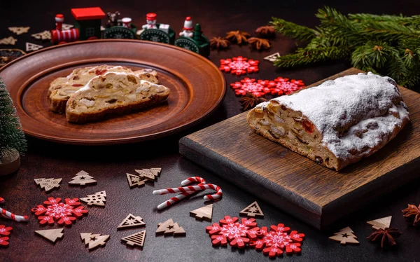 stock image Tasty christmas stollen with marzipans, dried fruits and nuts on a dark concrete background