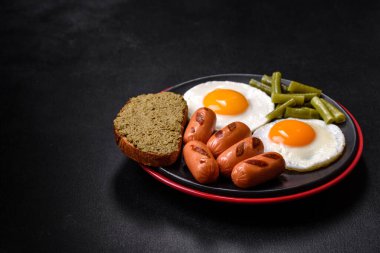 Yağda yumurta, fasulye, kuşkonmaz, baharatlı sosis ve çimento kaplı otlardan oluşan lezzetli bir İngiliz kahvaltısı.
