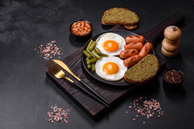 Yağda yumurta, fasulye, kuşkonmaz, baharatlı sosis ve çimento kaplı otlardan oluşan lezzetli bir İngiliz kahvaltısı.