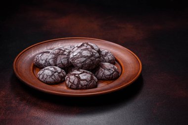 Koyu beton bir arka planda kahverengi bir tabakta güzel, tatlı kurabiyeli brownie.