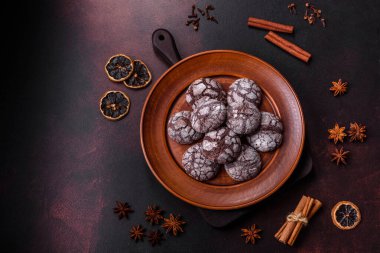 Koyu beton bir arka planda kahverengi bir tabakta güzel, tatlı kurabiyeli brownie.