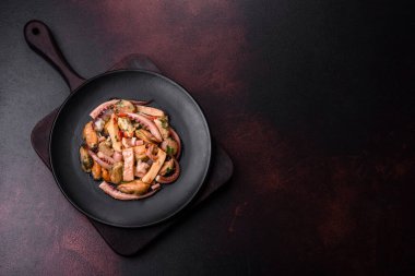 Lezzetli deniz ürünleri salatası ya da siyah tabakta koyu beton bir arka planda kokteyl.