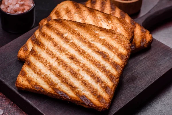 Tasty fresh crispy bread slices in the form of grilled toast for cooking delicious family breakfast