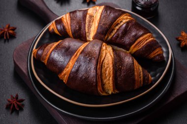 Koyu beton arka planda güzel, taze, çıtır kruvasan. Lezzetli bir kahvaltı için tatlı.