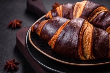 Koyu beton arka planda güzel, taze, çıtır kruvasan. Lezzetli bir kahvaltı için tatlı.