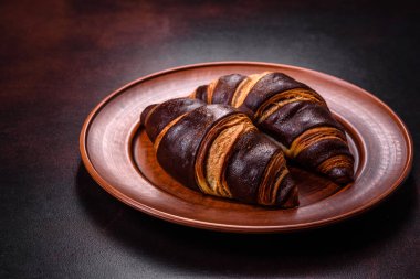 Koyu beton arka planda güzel, taze, çıtır kruvasan. Lezzetli bir kahvaltı için tatlı.