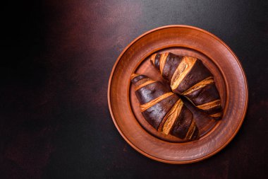 Koyu beton arka planda güzel, taze, çıtır kruvasan. Lezzetli bir kahvaltı için tatlı.
