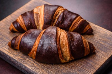 Koyu beton arka planda güzel, taze, çıtır kruvasan. Lezzetli bir kahvaltı için tatlı.