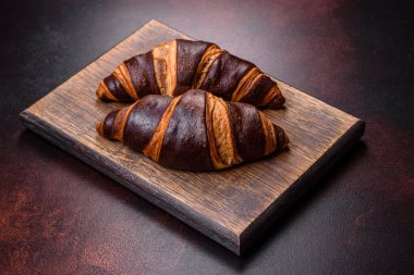 Koyu beton arka planda güzel, taze, çıtır kruvasan. Lezzetli bir kahvaltı için tatlı.