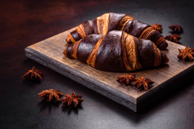 Koyu beton arka planda güzel, taze, çıtır kruvasan. Lezzetli bir kahvaltı için tatlı.