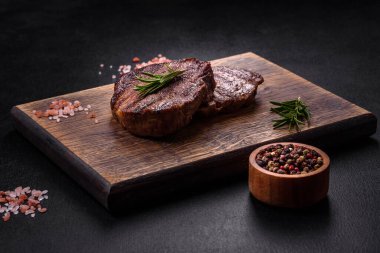 Lezzetli taze biftek, esrarlı baharatlar ve çimento kaplı otlar. Izgara yemek.