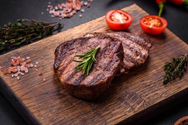 Lezzetli taze biftek, esrarlı baharatlar ve çimento kaplı otlar. Izgara yemek.