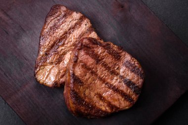 Lezzetli taze biftek, esrarlı baharatlar ve çimento kaplı otlar. Izgara yemek.