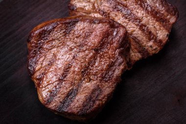 Lezzetli taze biftek, esrarlı baharatlar ve çimento kaplı otlar. Izgara yemek.