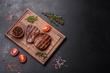 Lezzetli taze biftek, esrarlı baharatlar ve çimento kaplı otlar. Izgara yemek.