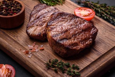 Lezzetli taze biftek, esrarlı baharatlar ve çimento kaplı otlar. Izgara yemek.