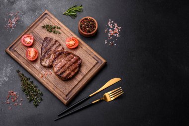 Lezzetli taze biftek, esrarlı baharatlar ve çimento kaplı otlar. Izgara yemek.