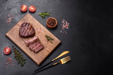 Lezzetli taze biftek, esrarlı baharatlar ve çimento kaplı otlar. Izgara yemek.