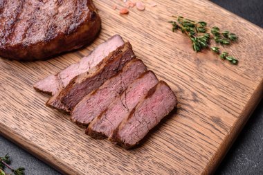 Lezzetli taze biftek, esrarlı baharatlar ve çimento kaplı otlar. Izgara yemek.